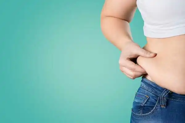 Image of woman pinching her love handles to show weight gain Stoulton